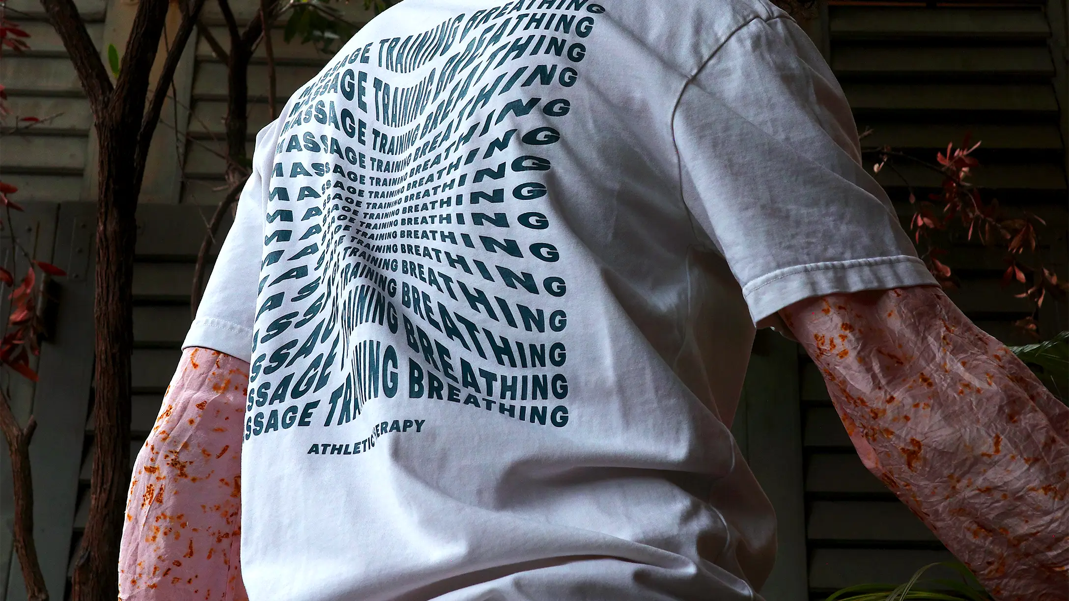 Ein bedrucktes T-Shirt draussen getragen, von hinten fotografiert
